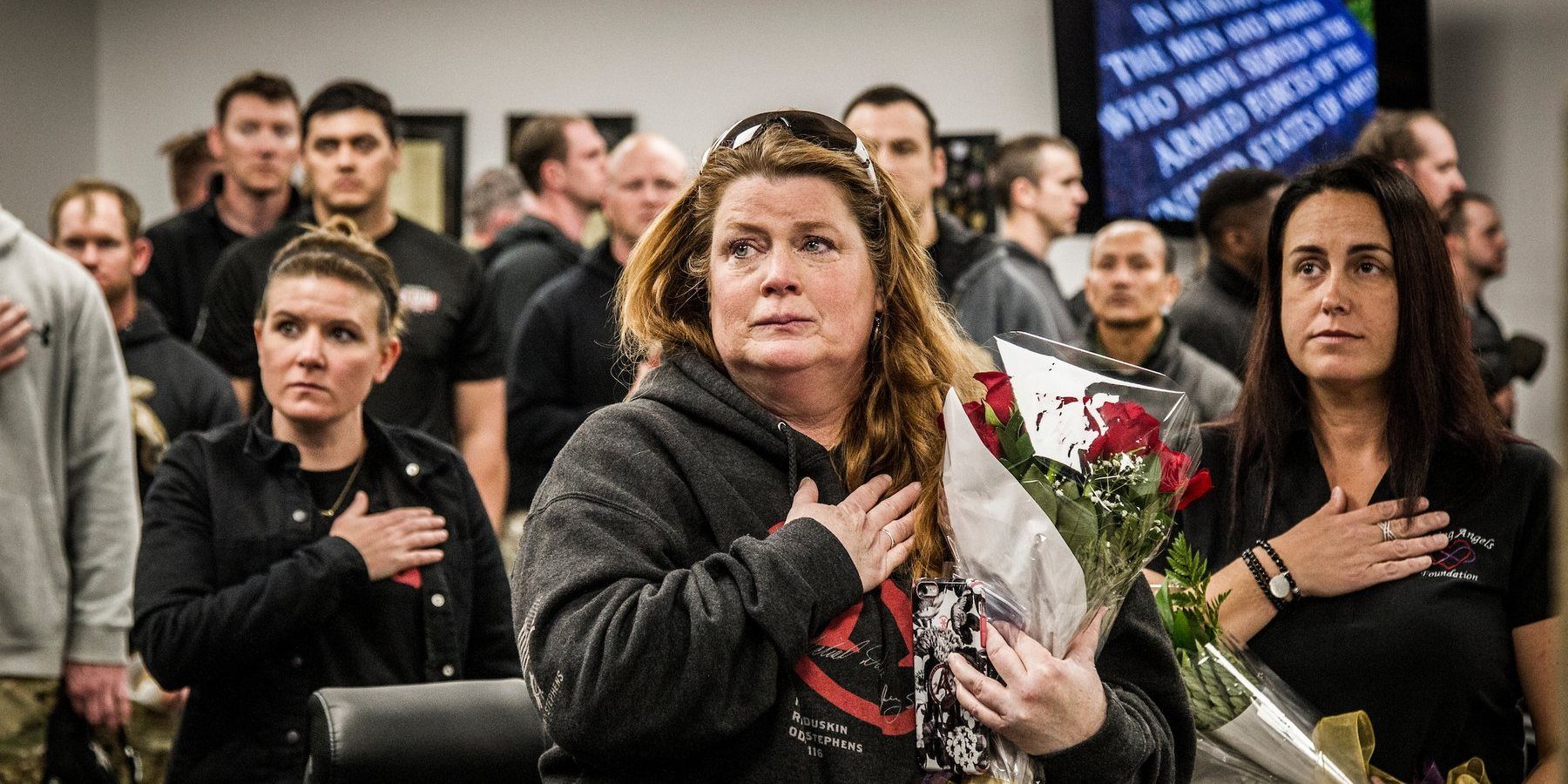 Gold Star and Surviving family members hold roses with hands over hearts during the 2018 Memorial 3 Gun honors