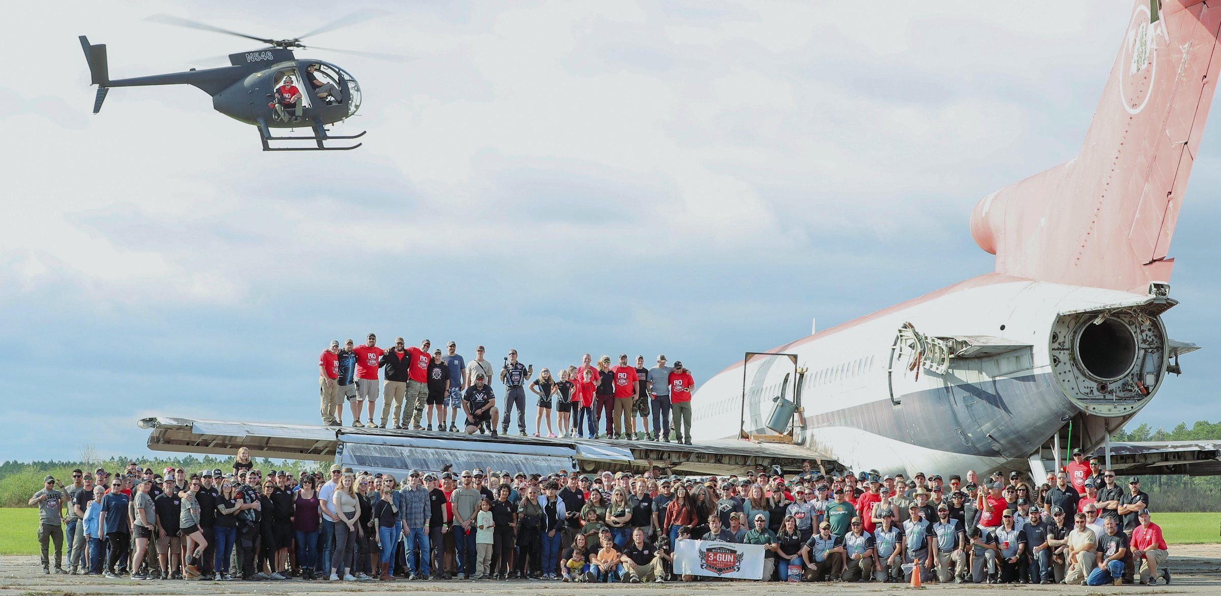 Memorial 3 Gun community gathered for a group photo by a helicopter