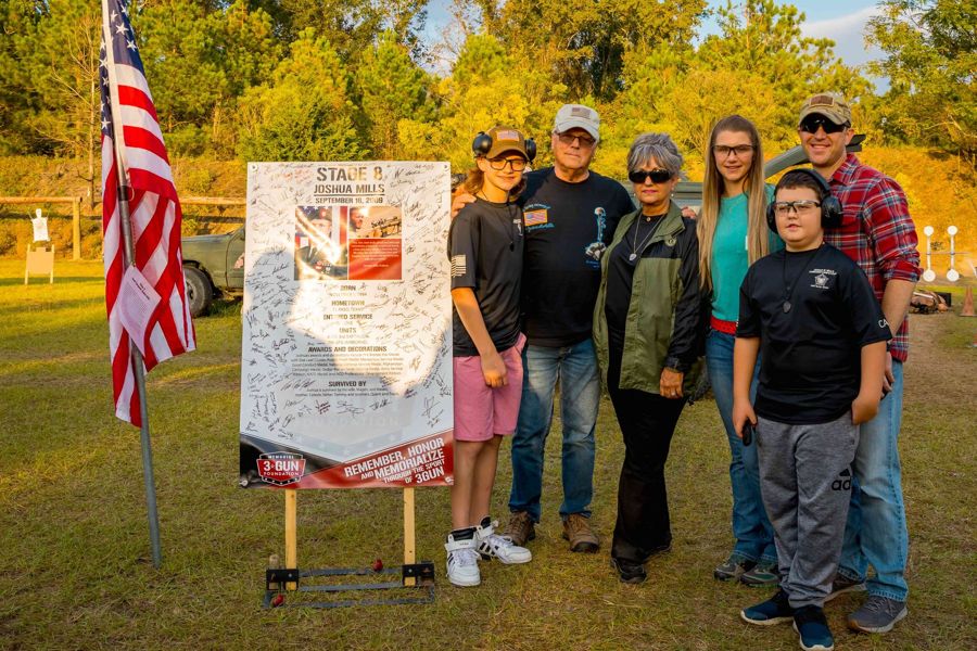 The family of SSG Joshua Mills gathers at his signed Stage 8 sign at the 2022 Memorial 3 Gun