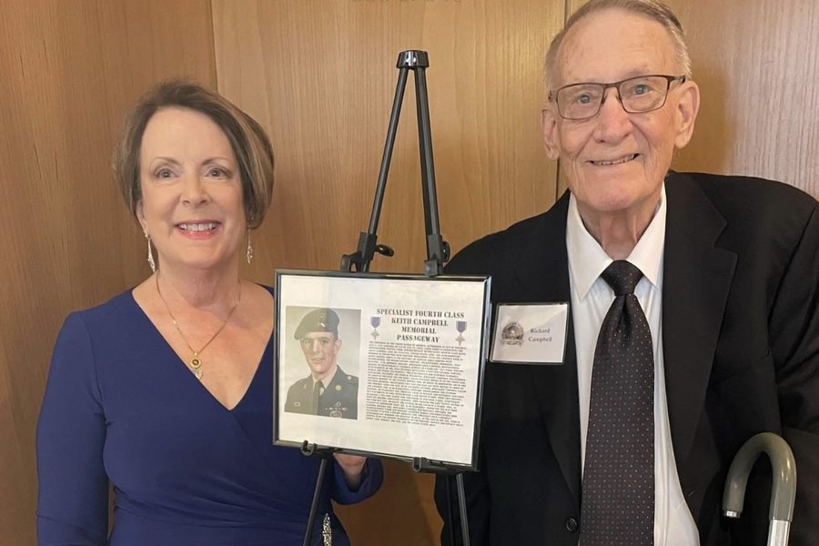 Family of SP4 Keith A. Campbell, a 2025 honoree, beside his memorial portrait, 2025